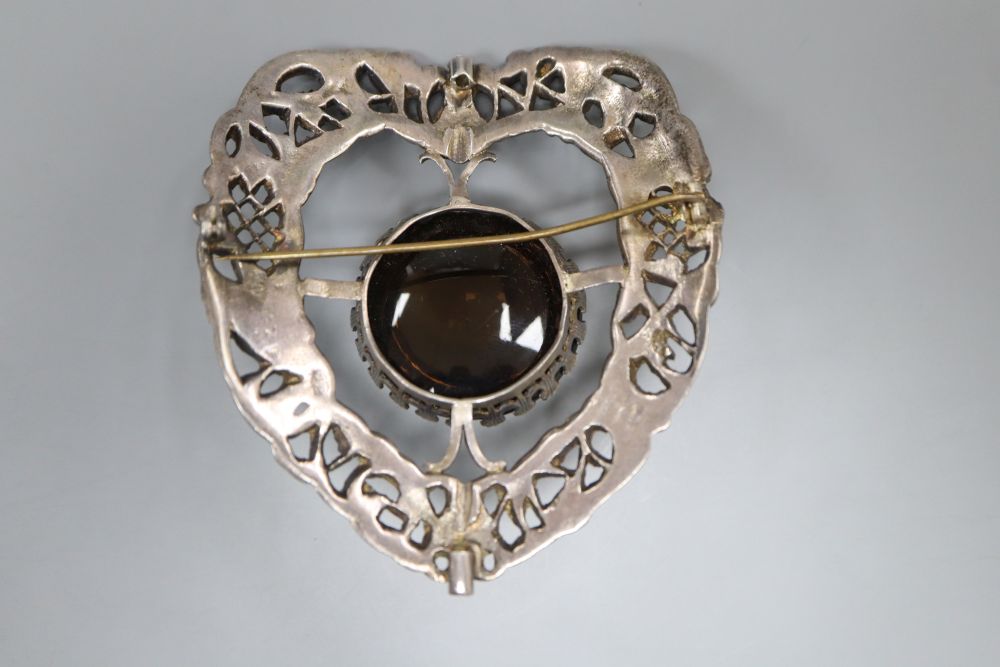 A large late Victorian pierced silver and cabochon quartz? set shield shaped brooch, 81mm.